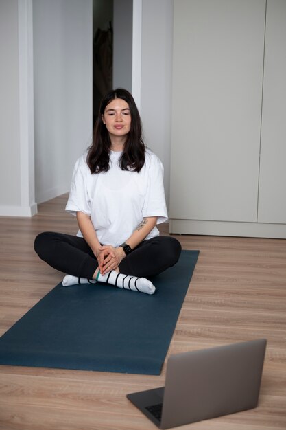 Vrouw doet thuis yoga tijdens quarantaine