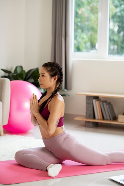 Vrouw doet yoga na online fitnessinstructeur