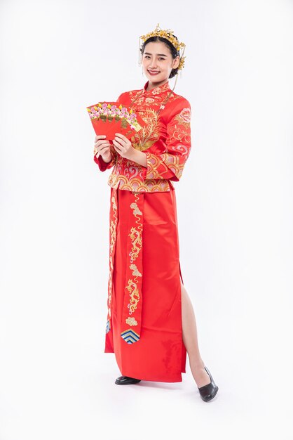 Vrouw draagt cheongsam-pak en zwarte schoen blij met het krijgen van cadeaugeld van de baas in Chinees Nieuwjaar