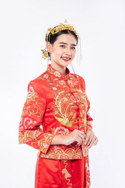 Vrouw draagt Cheongsam pak glimlach om reiziger te verwelkomen die in Chinees Nieuwjaar winkelt