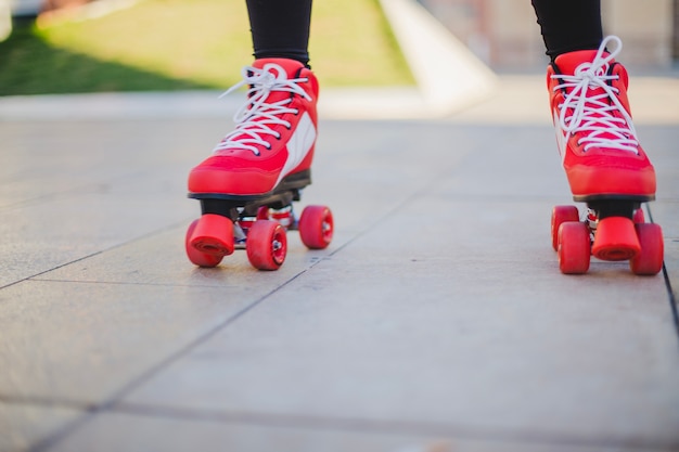 Gratis foto vrouw draagt ​​rollerskates rijden op de stoep