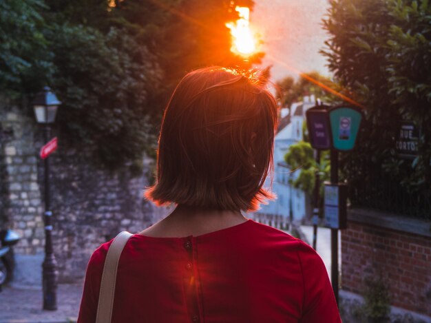 Vrouw draagt rood kijken naar zonsondergang