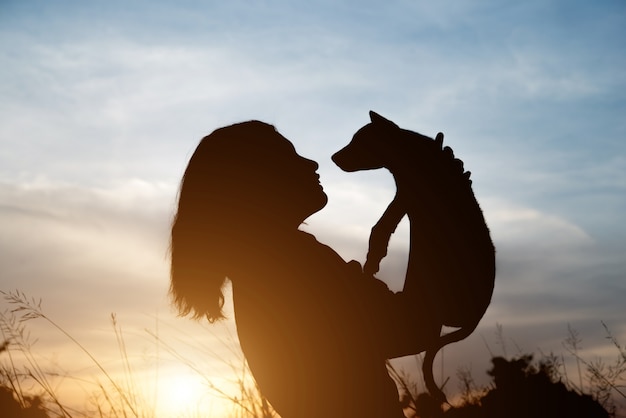 Vrouw dragen haar huisdier en knuffelen tot aan de hemel.