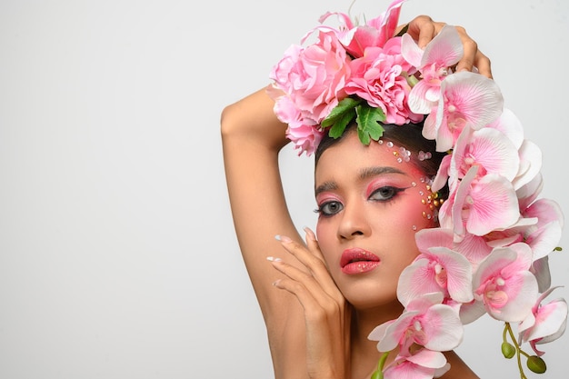 Vrouw droeg roze make-up en versierde prachtig de bloemen geïsoleerd op wit