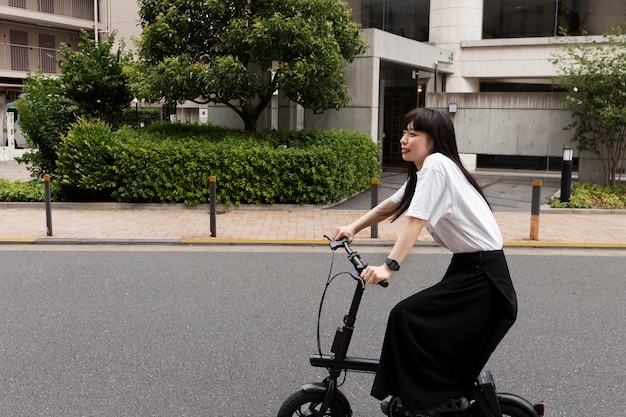 Vrouw elektrische fiets rijden in de stad