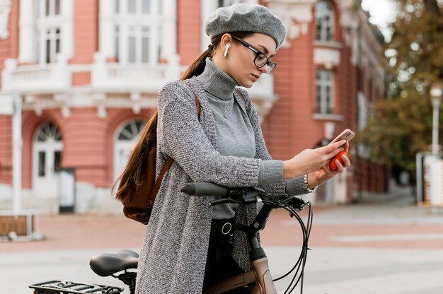 Vrouw en haar fiets met behulp van de mobiele telefoon