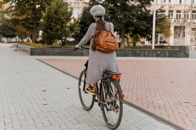Vrouw en haar fiets rijden door de straten