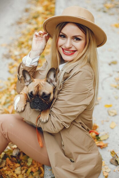 Vrouw en hond spelen en hebben plezier in het herfstpark