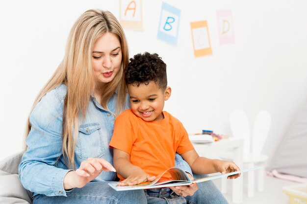 Vrouw en jonge jongen die thuis kijken