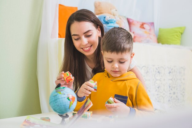 Vrouw en jongen kubussen spelen