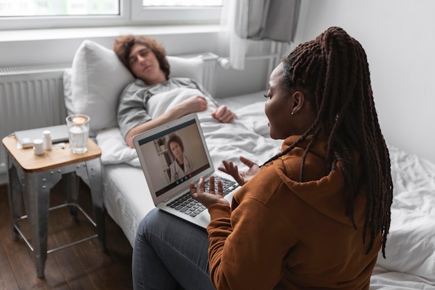 Vrouw en man praten met een arts via videocall