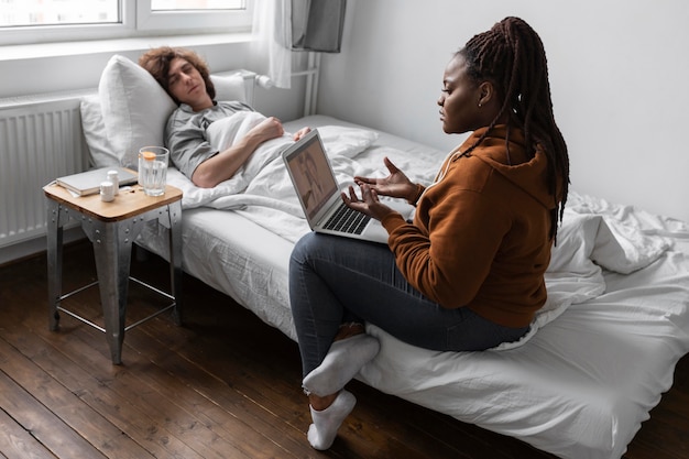 Vrouw en man praten met een arts via videocall