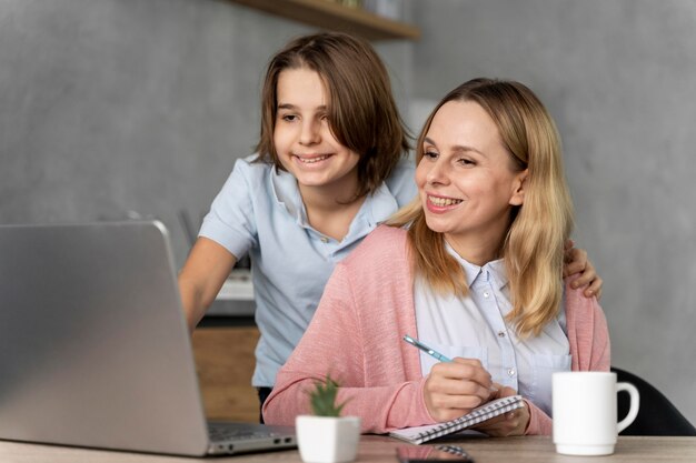 Vrouw en meisje die aan laptop werken