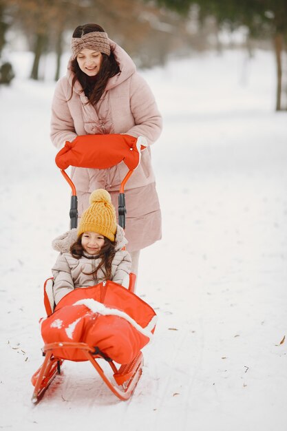 Vrouw en meisje in een park met slee