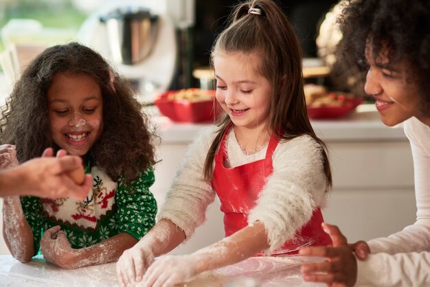 Vrouw en twee meisjes die kerstkoekjes voorbereiden