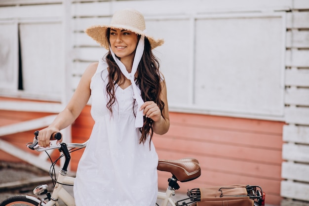 Vrouw fietsten in jurk en hoed
