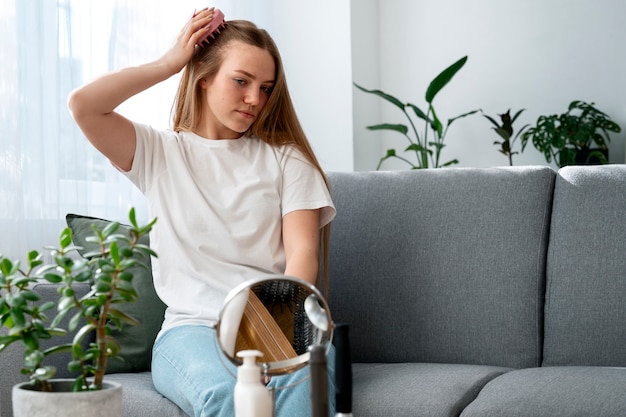 Vrouw geeft zichzelf een scalp massage.