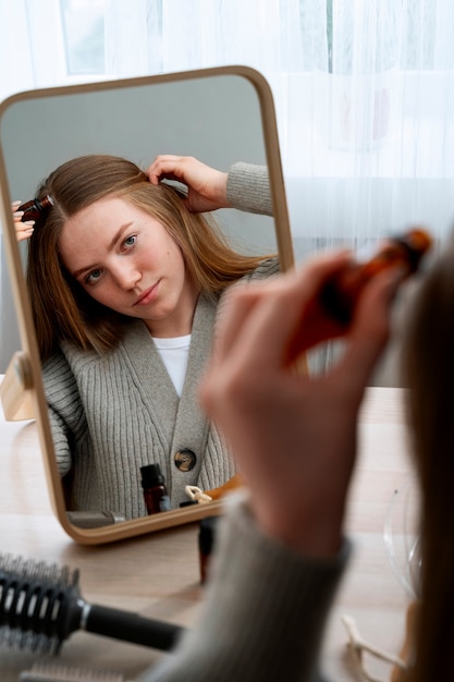 Gratis foto vrouw geeft zichzelf een scalp massage.