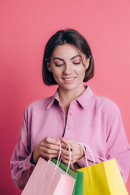 Vrouw, gekleed in casual trui op achtergrond gelukkig genieten van winkelen met kleurrijke tassen