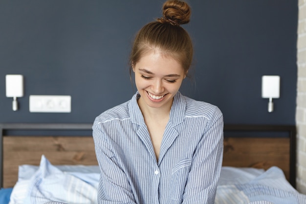 Gratis foto vrouw gekleed in pyjama zittend in bed