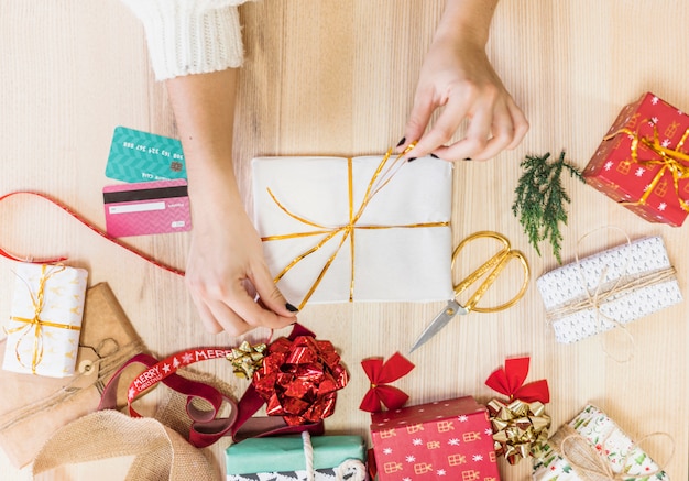 Gratis foto vrouw gelijkmakende strik op geschenkdoos