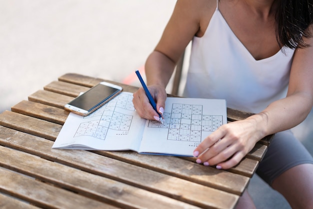 Gratis foto vrouw geniet alleen van een sudoku-spel