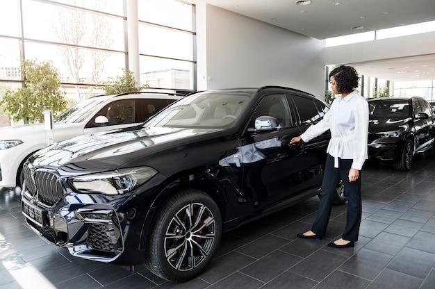 Vrouw geniet van haar financiële onafhankelijkheid terwijl ze een auto koopt