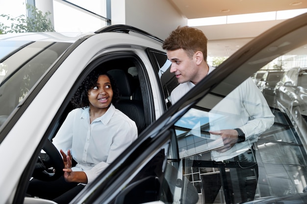 Vrouw geniet van haar financiële onafhankelijkheid terwijl ze een auto koopt