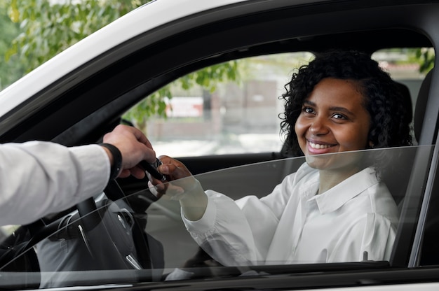 Vrouw geniet van haar financiële onafhankelijkheid terwijl ze een auto koopt