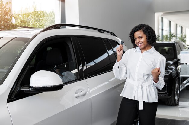 Vrouw geniet van haar financiële onafhankelijkheid terwijl ze een auto koopt
