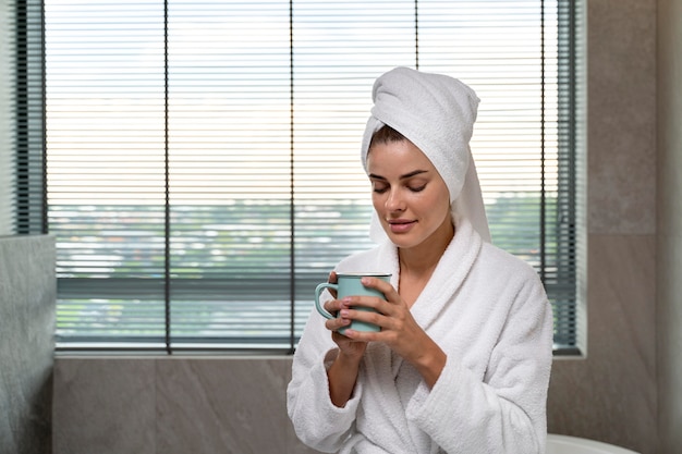 Vrouw geniet van koffie na haar bad