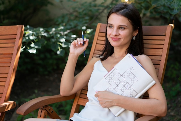 Gratis foto vrouw geniet zelf van een sudoku-spel op papier