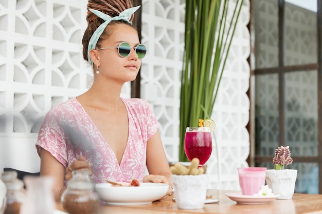 Vrouw genieten van dessert en drankje in café