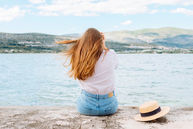 Vrouw genieten van het uitzicht op de oceaan met bergen