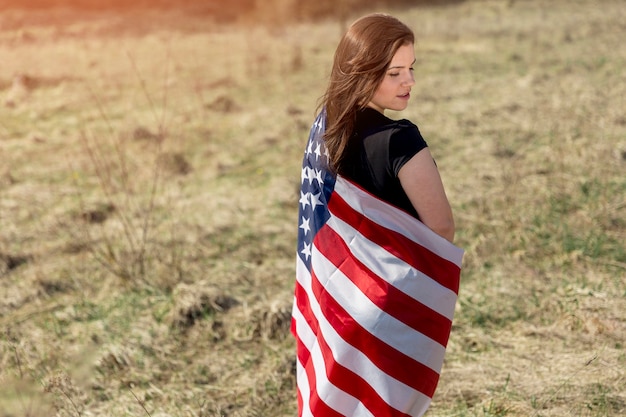 Vrouw gewikkeld in Amerikaanse vlag op veld