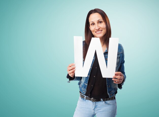 Vrouw glimlachend met de letter &quot;w&quot;