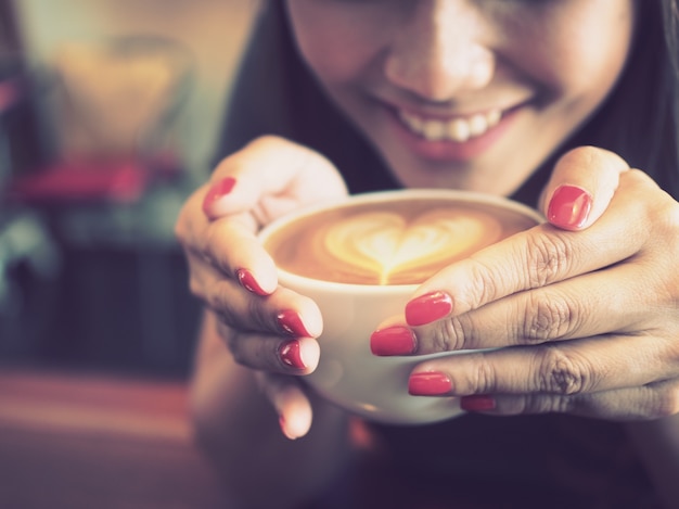 Vrouw glimlachend met een kopje koffie