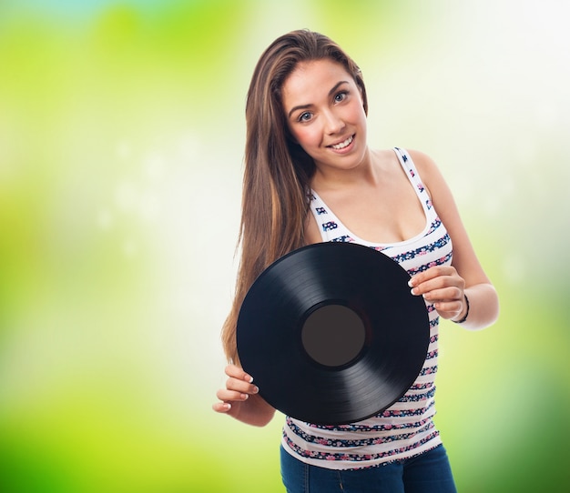 Vrouw glimlachend met een vinylplaat