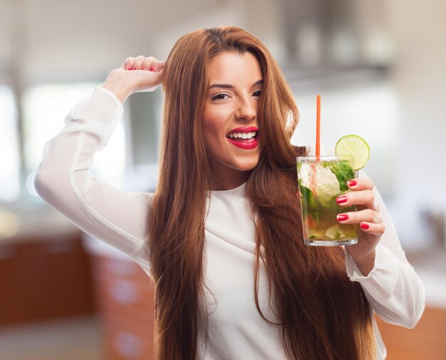 Vrouw glimlachend terwijl een glas met drank