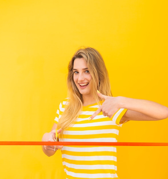 Gratis foto vrouw graag rood lint snijden