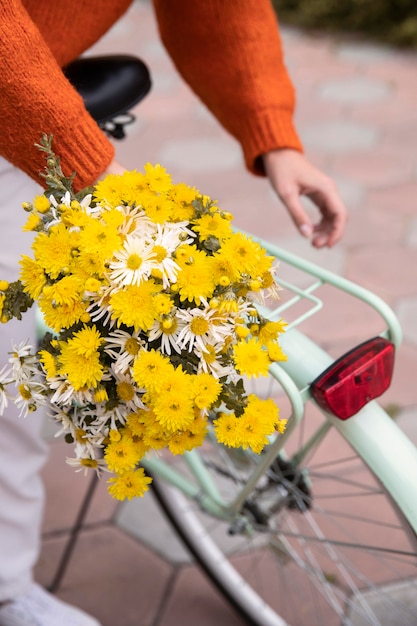 Vrouw grijpen fiets met boeket bloemen buitenshuis