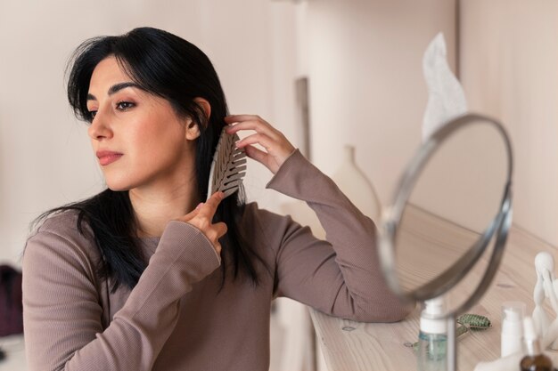 Vrouw haar kammen tijdens haar schoonheidsroutine