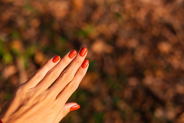 Vrouw hand met oranje manicure