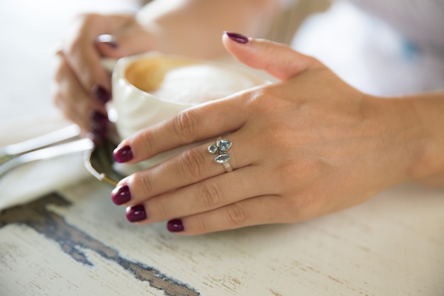 Vrouw hand met ring houden kopje cappuccino