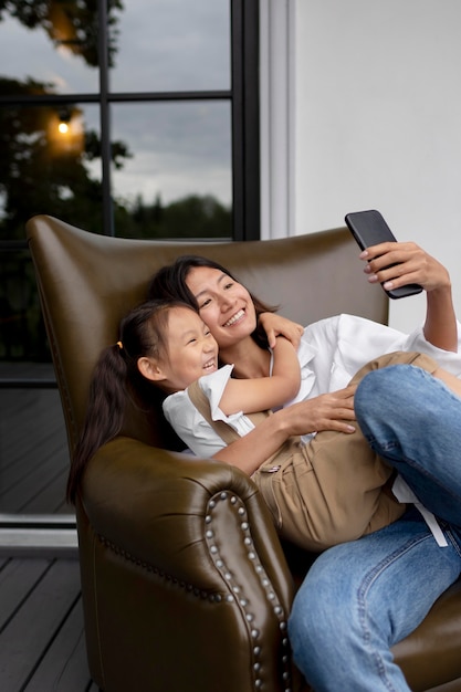 Gratis foto vrouw heeft een videogesprek met haar man naast hun dochter buitenshuis