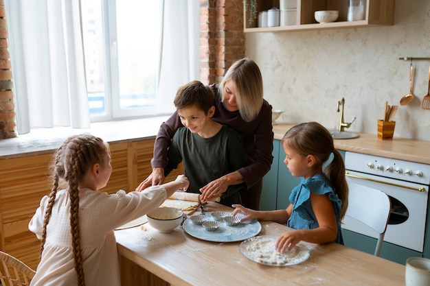 Vrouw helpt kinderen koken onder hoge hoek