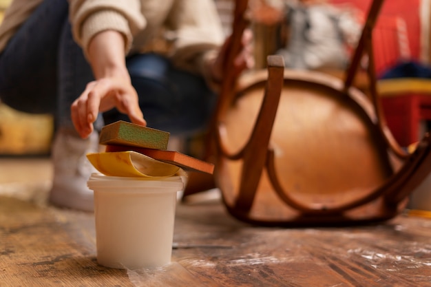 Gratis foto vrouw herstellen houten stoel vooraanzicht