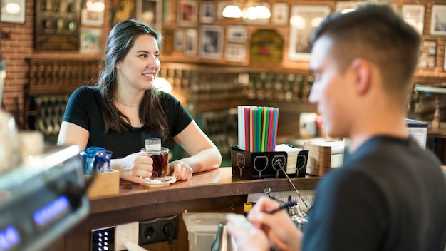 Vrouw het drinken thee terwijl man die orde neemt