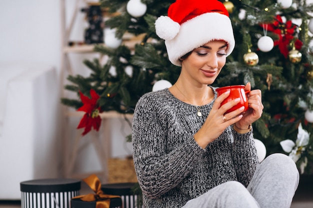 Vrouw het drinken van thee door de kerstboom