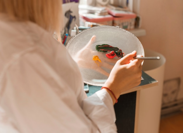 Gratis foto vrouw het schilderen met waterverf in studio